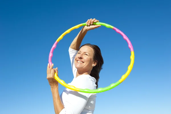 Active senior woman hula hoop exercise