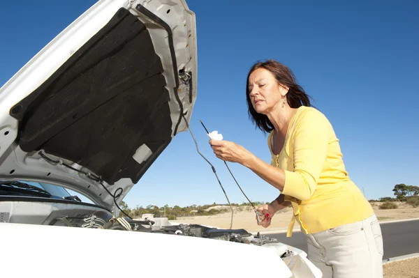Woman checking oil car