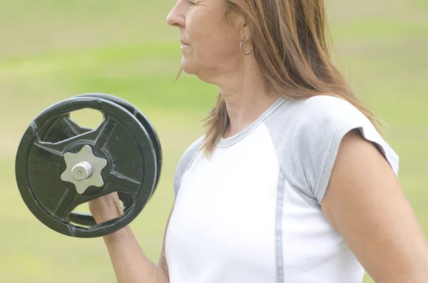 Mature woman weight lifting outdoor
