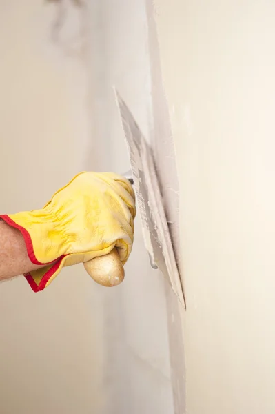 Home renovation wall with scraper and cement