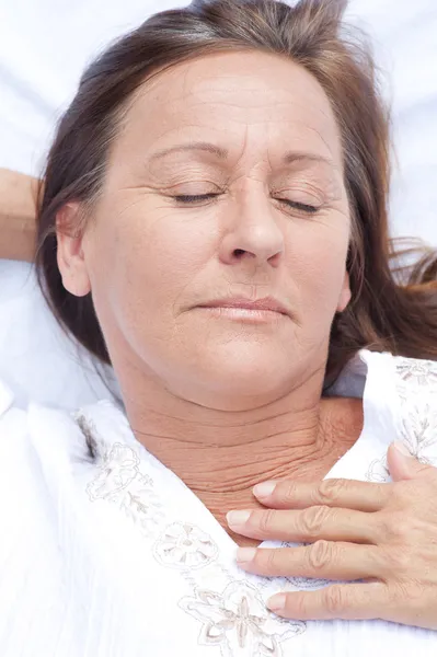 Happy mature woman asleep in bed