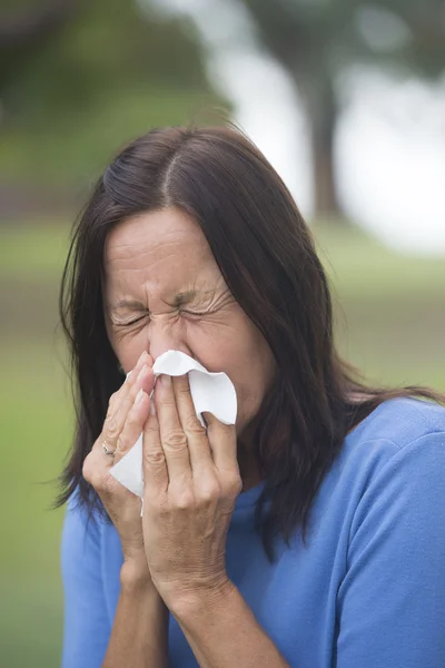 Woman sneezing tissue with flu or hayfever