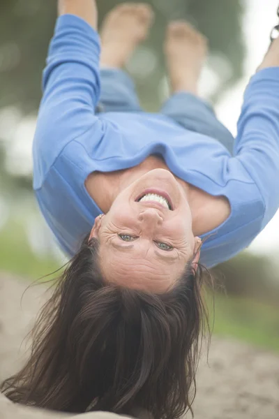 Attractive mature woman on swing upside down