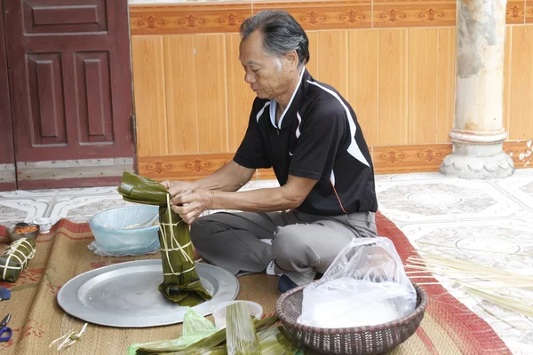Asian man packing rice cake