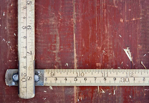 Old meter stick on old wooden background