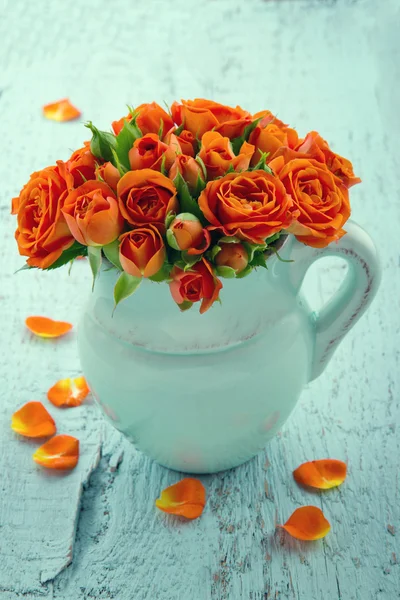 Bouquet of orange roses in a blue vase