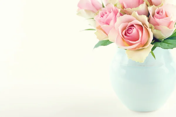 Pink roses in a light blue vase