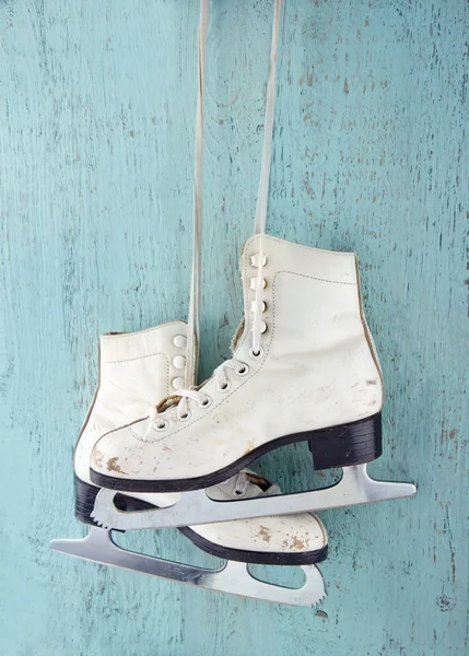 Pair of ice skates on blue wooden background