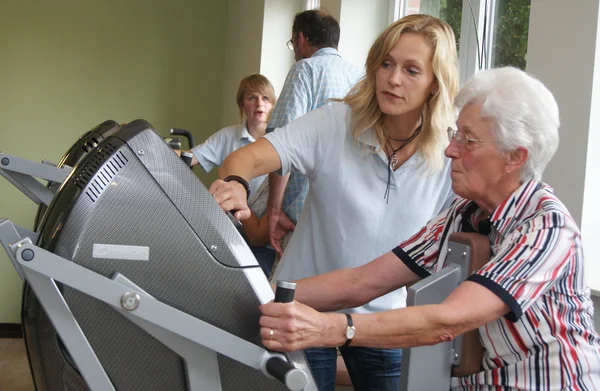Physiotherapist with healthy old woman