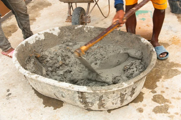 Builder worker during using hoe to mix wet cement