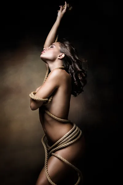 Young woman wrapped in rope