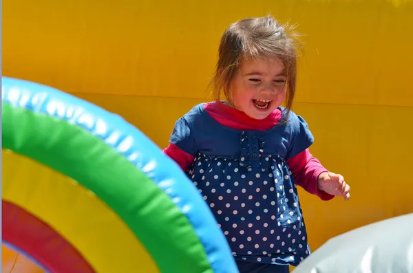 Little girl play in inflatable jumper playground