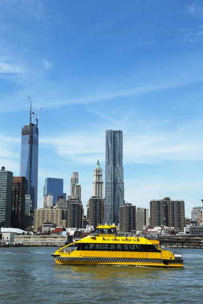 New York City Water Taxi with Freedom Tower and NYC skyline seen from Brooklyn Bridge Park