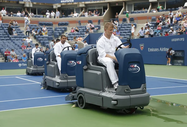 US Open cleaning crew drying tennis court after rain delay at Arthur Ashe Stadium