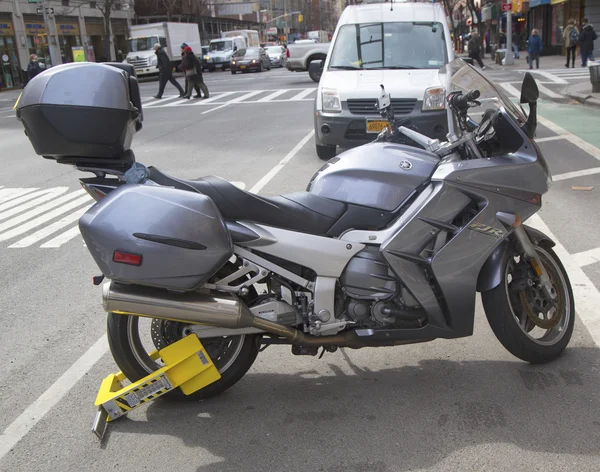 Wheel lock on an illegally parked motorcycle in Manhattan