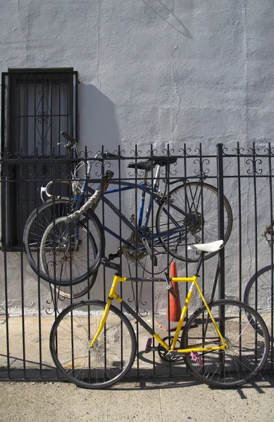 Old bicycles parked and locked to metal gate in Brooklyn, New York