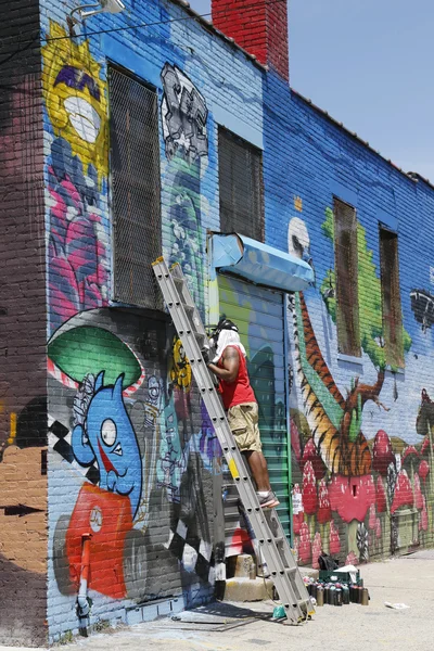Street artist painting mural at Williamsburg in Brooklyn