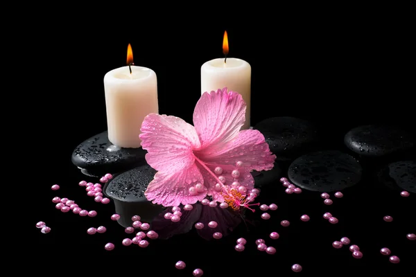 Beautiful spa still life of pink hibiscus, candles, zen stones w