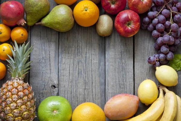 Fresh fruits on wooden boards frame background