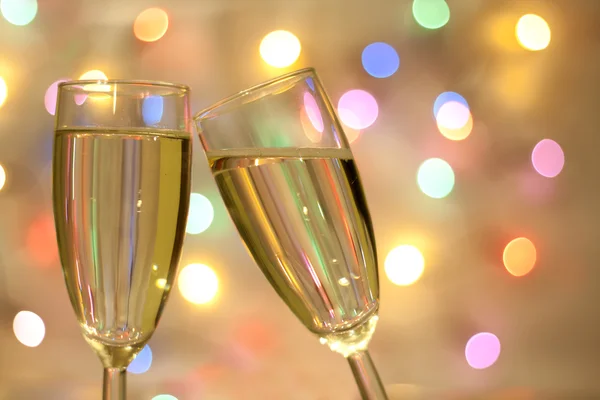 Two glasses of champagne on blurred new year party background