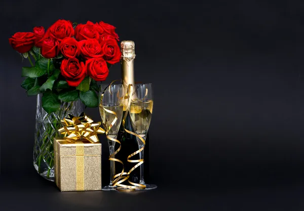 Red roses and champagne with golden decoration