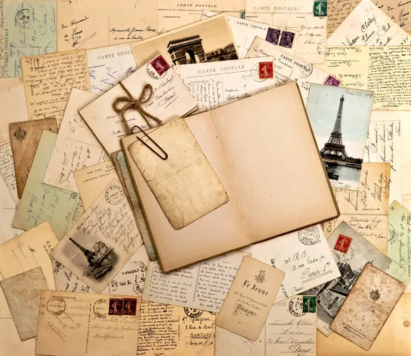 Old letters, french postcards from Paris and open book