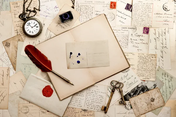 Open book, old keys, clock and postcards