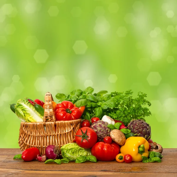 Fresh vegetables and herbs over green background