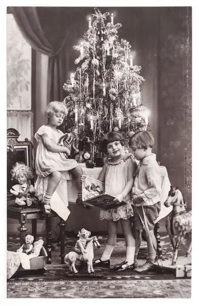 Happy kids with christmas tree, gifts and vintage toys