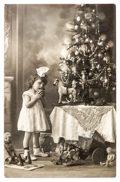 Antique photo of littele girl with christmas tree and vintage to