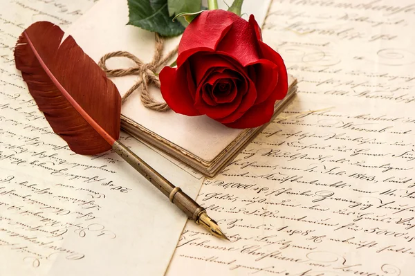 Old letters, rose flower and antique feather pen