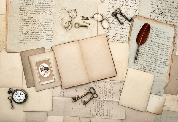 Open book, old letters, postcard, photo, keys, clock