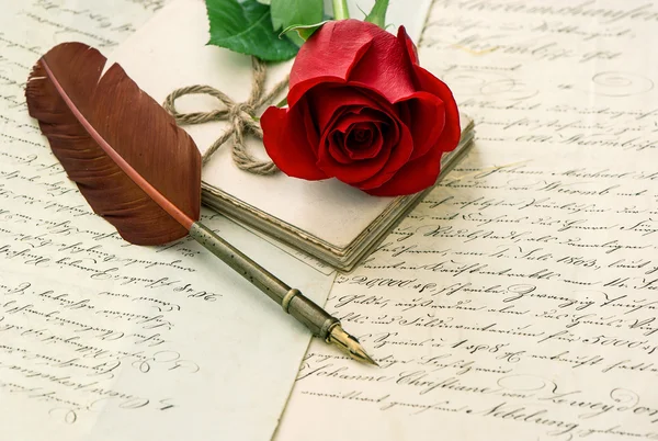 Old letters, rose flower and antique feather pen