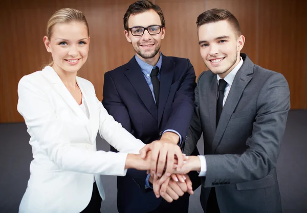 Business partners making pile of hands