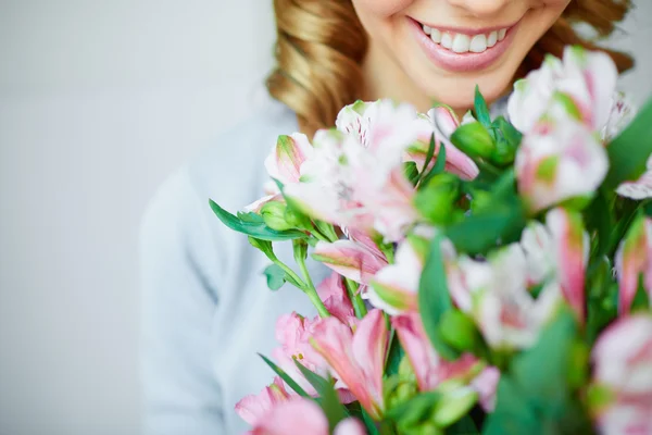 Girl smelling pink flowers