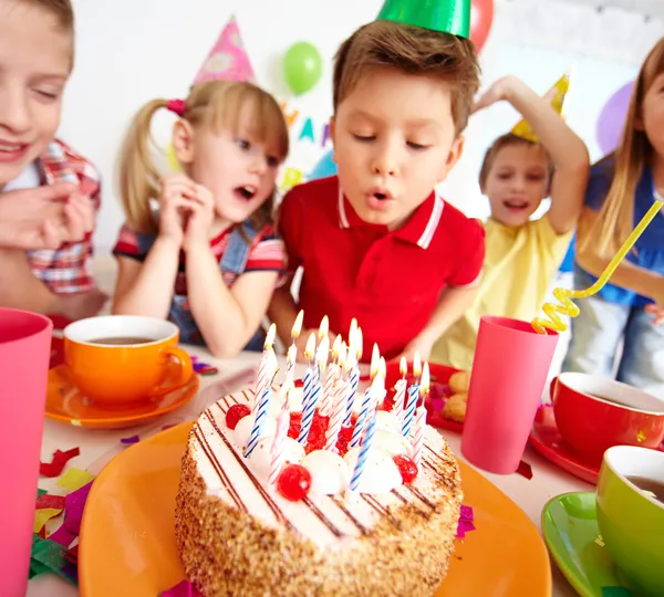 Boy blowing on cake with candles