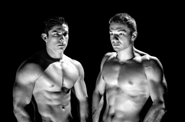 Two muscular men standing black and white