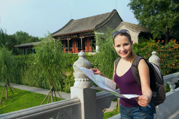 Caucasian woman with map and backpack travel in China