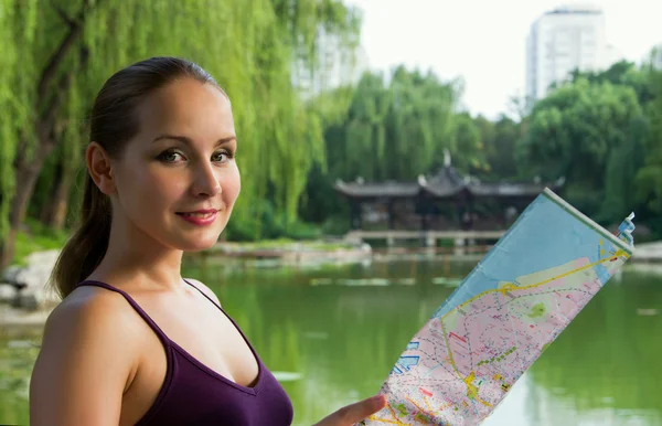 Young tourist woman holding map. Student travel in China