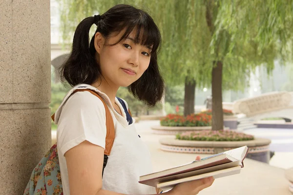 Young Asian girl studying hard in the park