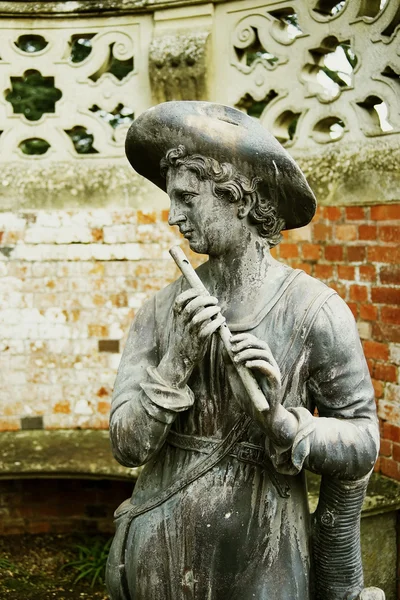 Old statue man with flute