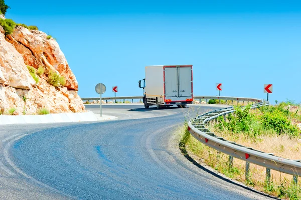 Truck driving on a mountain road on a sunny day