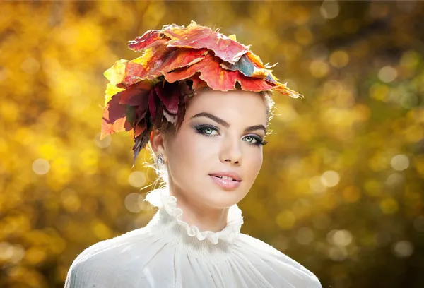 Autumn Woman. Beautiful creative makeup and hair style in outdoor shoot .Beauty Fashion Model Girl with Autumnal Make up and Hair style. Fall. Creative Autumn Makeup. Beautiful fashionable girl.