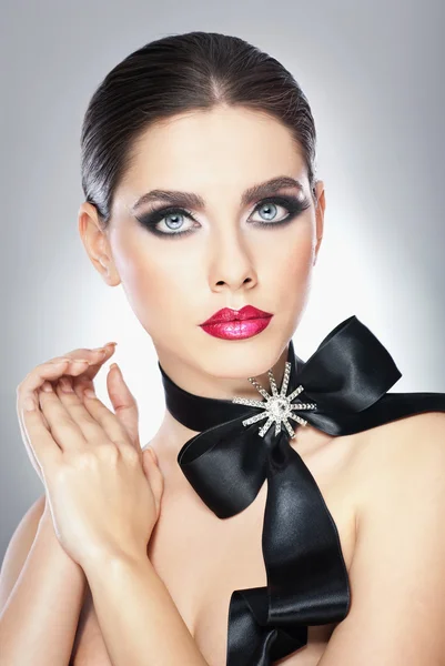 Hairstyle and Make up - beautiful female art portrait with black ribbon. Elegance. Genuine Natural brunette with ribbon - studio shot. Portrait of a attractive woman with beautiful eyes and red lips