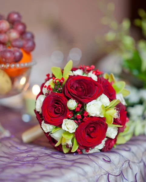 Beautiful bouquet of rose flowers, on table. Wedding bouquet of red roses. Elegant wedding bouquet on table at restaurant