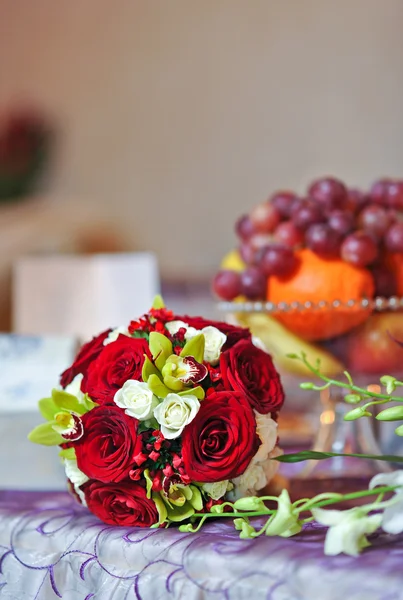 Beautiful bouquet of rose flowers, on table. Wedding bouquet of red roses. Elegant wedding bouquet on table at restaurant