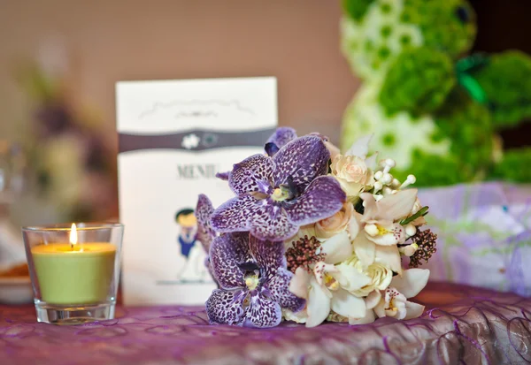 Wedding decorations with candle. Floral arrangements on wedding ceremony detail. Elegant wedding arrangement with flowers, candle and card