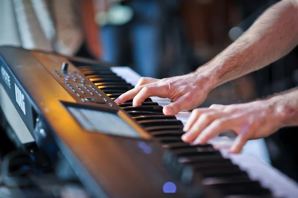 Closeup shot of male hands playing the piano. Human hands playing the piano on the party.  Man playing the synthesizer keyboard
