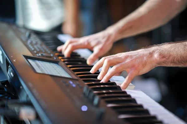 Closeup shot of male hands playing the piano .Human hands playing the piano on the party .
