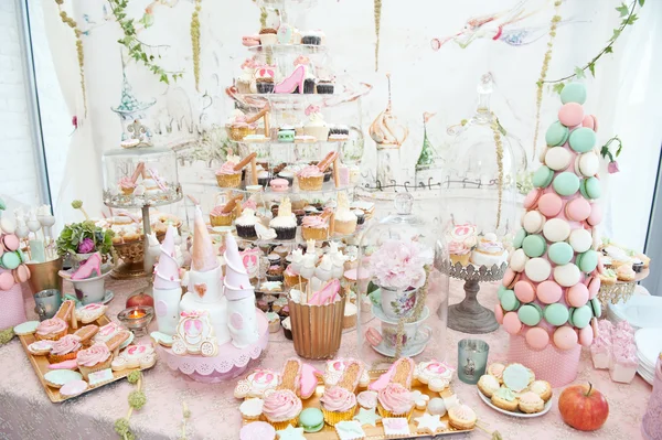 Wedding decoration with pastel colored cupcakes, meringues, muffins and macarons. Elegant and luxurious event arrangement with colorful macaroons. Wedding dessert with macaroons